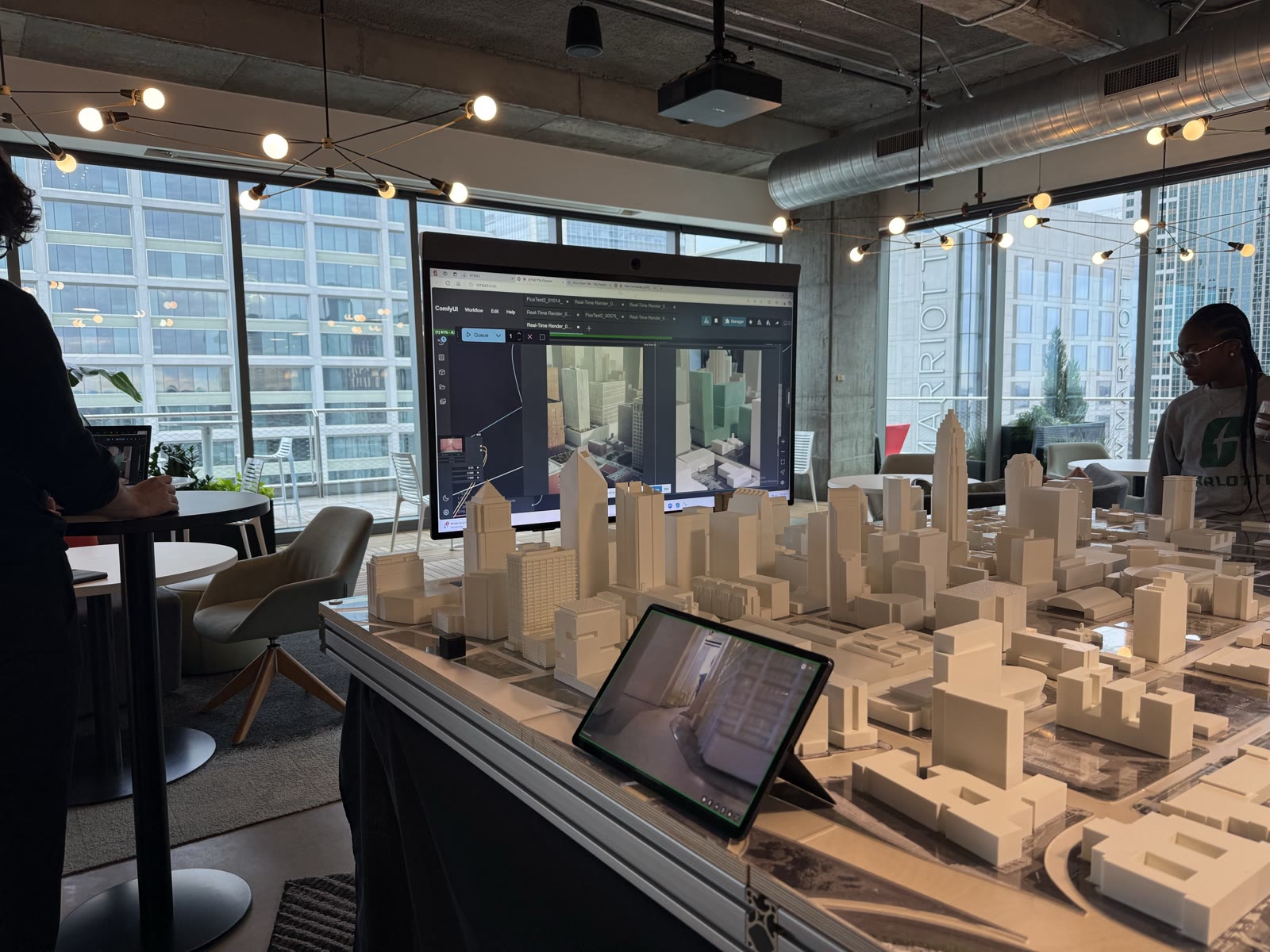 Large city massing model in the office with the live render on a big screen